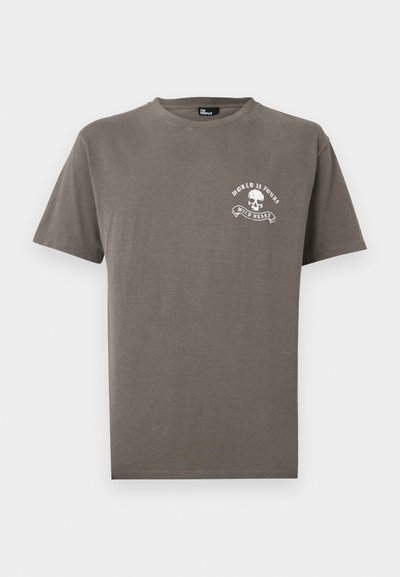 Καφέ κοντομάνικη μπλούζα με στρογγυλή λαιμόκοψη, με μικρό λευκό κρανίο και το κείμενο «WORLD IS YOURS» και «WILD HEART» στο αριστερό στήθος.