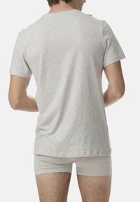 Jasnoszara bawełniana koszulka z krótkim rękawem i okrągłym dekoltem, widoczna z tyłu. W zestawie z pasującymi jasnoszarymi szortami.