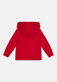 Felpa rossa con cappuccio regolabile, maniche lunghe e polsini a costine. Tessuto morbido, senza loghi o motivi visibili.
