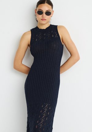 Vestito senza maniche in maglia blu navy scuro con costine verticali e motivo in pizzo sul fondo. Silhouette aderente, tessuto strutturato.
