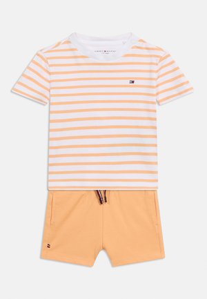 Ensemble pour tout-petit composé d'un haut à manches courtes rayé blanc et orange et d'un short uni orange avec cordon de serrage.