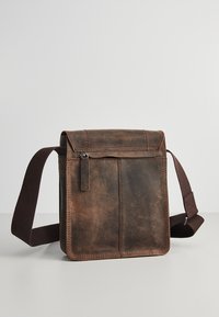 Borsa a spalla in pelle marrone con pattina. Presenta una tasca frontale e una tracolla in tessuto regolabile. Finitura testurizzata con dettagli di cucitura visibili.