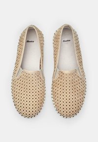 Barna slip-on cipők perforált felsőrésszel, kerek orral és világos színű varrással a talp körül. A márkaneve "Bata" a belsejében található.
