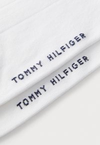 Balti medvilniniai kojinės su išsiuvinėtu "TOMMY HILFIGER" tekstu jūros mėlyna spalva. Lygus paviršius su suteikta tekstūra, kad būtų didesnis elastingumas.