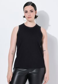 Czarny bezrękawnik z okrągłym dekoltem. Wykonany z gładkiego materiału, z skórzanymi akcentami na dekolcie i otworach na ramiona.