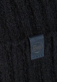 Close-up of black knitted fabric with a small dark leather tag stitched, featuring the embossed "Buff" logo.