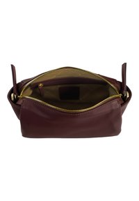 Borsa in pelle bordeaux con chiusura superiore a zip e hardware dorato. Texture liscia e interno foderato con tasche per l'organizzazione.