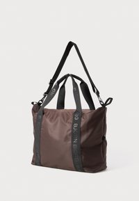 Καφέ νάιλον τσάντα ώμου με μαύρες νάιλον λωρίδες. Διαθέτει λογότυπο στις λωρίδες και κλείσιμο με φερμουάρ στην κορυφή. Λείος υφασμάτινος χαρακτήρας, ορθογώνιο σχήμα.