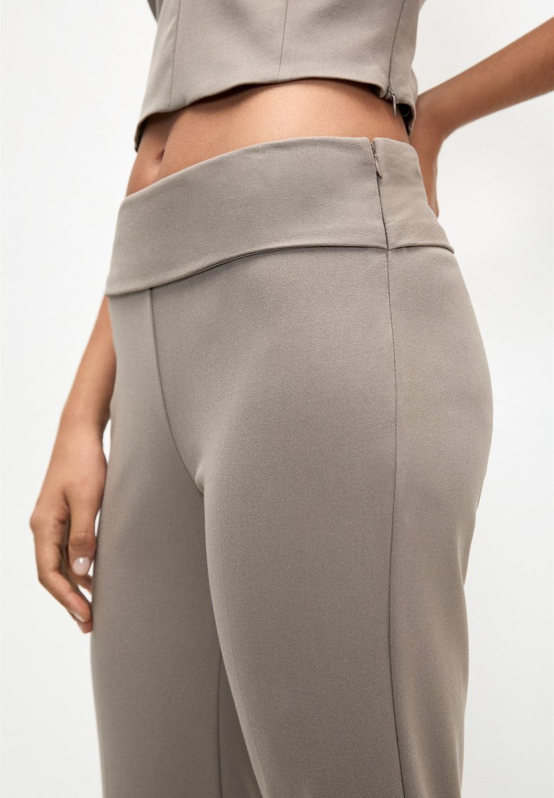 Graue, hochtaillierte Hose aus glattem Stoff, mit breitem Bund und tailliertem Schnitt, seitlichen Nähten und sauberem Finish.