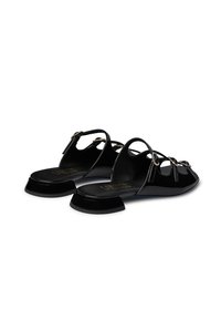 Sandali in vernice nera con tacco basso a blocco, dotati di lati aperti e decorazioni in metallo dorato sulle cinghie frontali.