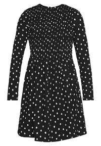 Czarna sukienka z długim rękawem w białe kropki, z marszczonym stanikiem i rozkloszowanym dołem, wykonana z lekkiego materiału.