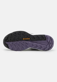 Suola di scarpa da ginnastica nera e viola con profondi tasselli di trazione, superficie in gomma testurizzata e logo "Continental" arancione ben visibile.