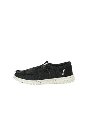 Scarpa casual nera intrecciata slip-on con suola bianca screziata e cuciture decorative marroni, vista di lato su sfondo bianco.