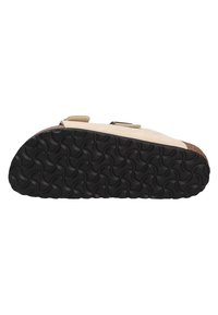 Beige sandal with a textured black rubber sole, featuring a dual straps design and a subtle metallic buckle accent.