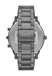 Montre-bracelet en métal gris avec un bracelet à maillons. Elle présente un boîtier arrondi, un fond en verre et un logo "DIESEL" gravé sur le fermoir.