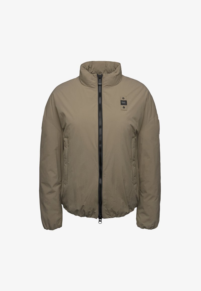Lightweight beige jacket with a high collar, full front zipper, and two side pockets. Features a black zipper and a branded patch on the chest.