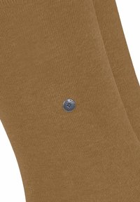 Brązowe skarpetki z dzianiny o gładkiej fakturze i srebrnym guzikiem z logo. Projekt jest prosty z jednolitą kolorystyką i bez wzorów.