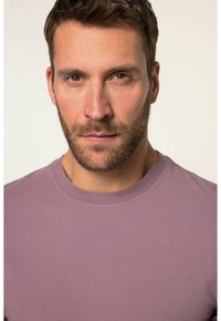 Kortærmet t-shirt med rund hals i dæmpet lavendel. Blødt bomuldsstof med en glat tekstur og minimale sømdetaljer.