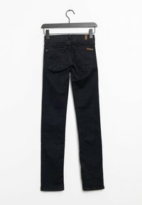 Jeans de mezclilla negra, de corte slim, que cuentan con dos bolsillos traseros con costuras sutiles y una etiqueta de cuero en la parte trasera de la cinturilla.