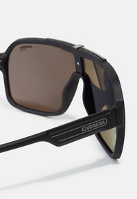 Ochelari de soare negri cu lentile maro, având un finisaj mat, formă rectangulară, accente din metal și logo-ul "CARRERA" pe brate.
