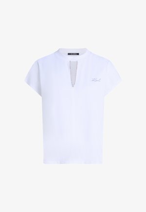 Fehér rövidujjú póló magas nyakkal, elülső lánc díszítéssel és szürkére hímzett "Karl" logóval a bal oldalon.