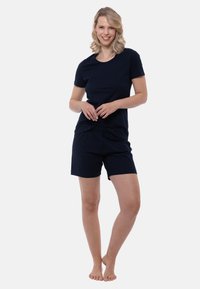 Marinblå bomullströja i kombination med matchande shorts. T-shirten har rund halsringning och korta ärmar, medan shortsen har resår i midjan.