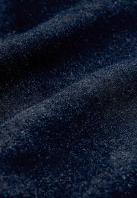 Granatowy materiał o teksturowanej powierzchni, prezentujący delikatne, subtelne wariacje w odcieniu oraz drobną, tkane wzory.