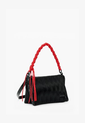 Zwarte leren handtas met geplooide details en een gevlochten rood handvat, voorzien van franjes en een gestructureerde vorm. Ritssluiting en verstelbare schouderriem.