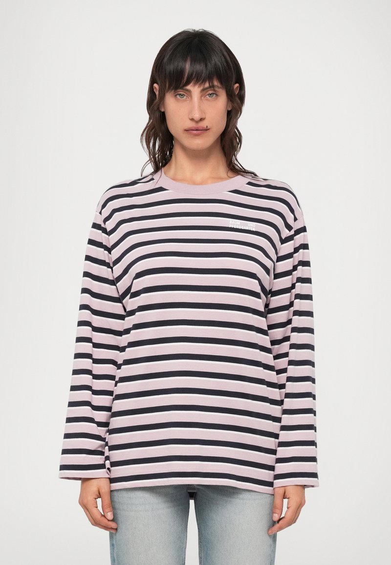 Pikkade varrukatega triibuline särk, millel on horisontaalsed mustad ja heledat roosa triibud, ümar kaelus ja väike logo rinnal.