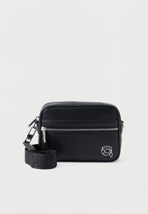 Black crossbody bag made of textured leather, featuring a front zipper pocket, adjustable strap with logo, and a small embroidered detail.
