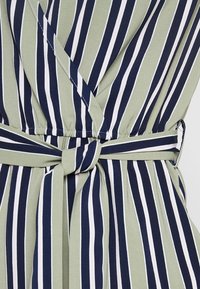 Vestito avvolgente a righe nei colori verde oliva, blu navy e bianco. Caratterizzato da una cintura annodata e un tessuto morbido e leggero.