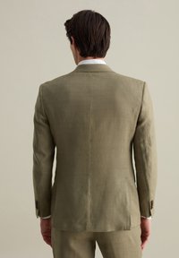 Olivgrüne Leinenanzugjacke mit einem Schlitz, mit Revers und geknöpften Manschetten. Texturiertes Gewebe, taillierter Schnitt, minimale Nähdetails.