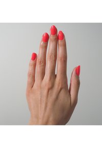 Korallfarbiger Nagellack auf manikürten Fingern mit einer glatten Textur; eleganten ovalen Form und glänzendem Finish vor einem neutralen Hintergrund.