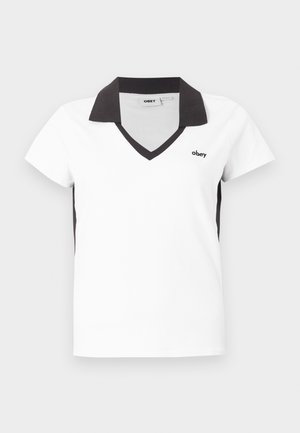 Λευκό κοντομάνικο πόλο με μαύρο γιακά, μαύρη διακόσμηση V-λαιμόκοψης, μαύρες πλαϊνές πάνελ και μικρό λογότυπο "obey" στο αριστερό στήθος.
