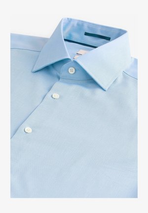 Hele sinine nööbitav särk, mis on valmistatud reljeefsest kangast. Särk sisaldab klassikalist kraed ja kolme nööbi esiosas. Mustreid ei ole nähtaval.