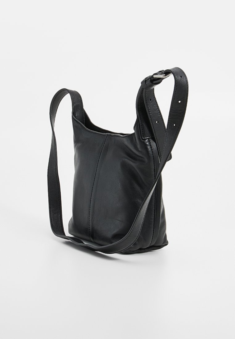 Schwarze Leder-Umhängetasche mit verstellbarem Riemen und silberner Schnalle, vor einem schlichten weißen Hintergrund präsentiert.