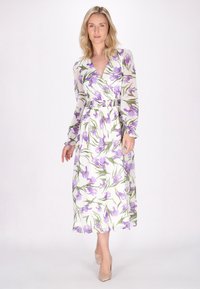 Rochie maxi cu model floral, confecționată dintr-un material ușor și transparent. Are decolteu în V, mâneci lungi, talie strânsă și o siluetă fluidă.