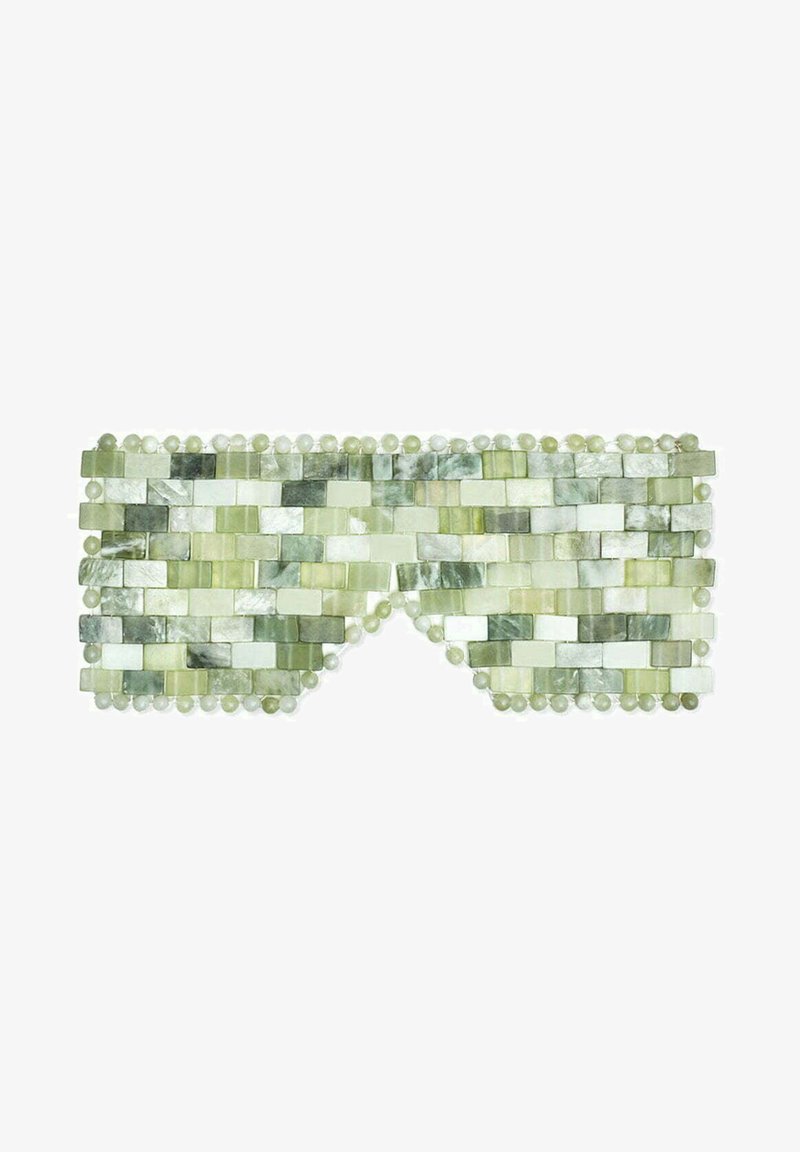 Masque oculaire en mosaïque verte composé de petits morceaux de pierre rectangulaires, présentant diverses nuances de vert, avec des perles rondes le long des bords.