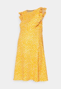 Żółta sukienka w białe kropki, z krótkimi falbaniastymi rękawami i rozkloszowanym fasonem. Wykonana z lekkiego materiału o gładkiej fakturze.