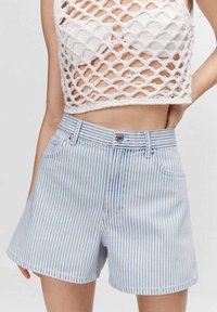 Džínové šortky s vysokým pasem, světle modré a bílé horizontální pruhy, zapínání na knoflík a přední kapsy. Texturovaný pletený crop top.