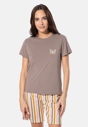 Graues Baumwoll-T-Shirt mit Rundhalsausschnitt und kurzen Ärmeln, mit einem weißen Schmetterlingsmotiv auf der linken Brust. Kombiniert mit gestreiften Shorts.