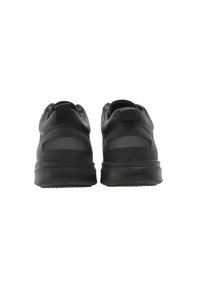 Scarpe da ginnastica nere con colletto imbottito, dettagli in rete e suola in gomma testurizzata. La vista posteriore mostra un tallone rinforzato e un branding minimale.