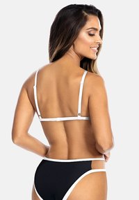 Czarny zestaw bikini z teksturowanym dołem i białymi akcentami oraz regulowanymi ramiączkami. Widok z tyłu podkreśla minimalistyczny design.