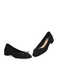 Bailarinas de ante negro con la punta redondeada, un pequeño tacón y un lazo decorativo en la parte delantera. Textura suave, diseño minimalista.