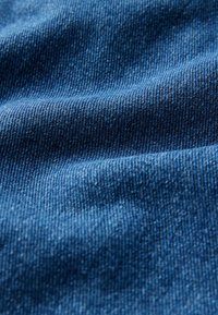 Zila denima auduma, kuram ir gluda tekstūra ar smalkiem vertikāliem rievām un smalku spīdumu. Audumam ir nelieli krokas un viļņi.