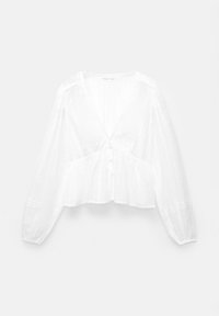 Blouse blanche avec de longues manches bouffantes, un décolleté en V, une fermeture à boutons et des rayures verticales avec des points texturés.
