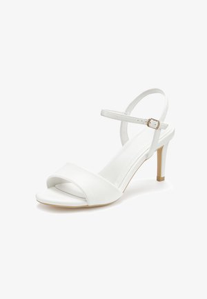 Weiße High-Heel-Sandale mit offenem Zehenbereich, vorderem Riemen, verstellbarem Knöchelriemen und schlankem Absatz vor weißem Hintergrund.