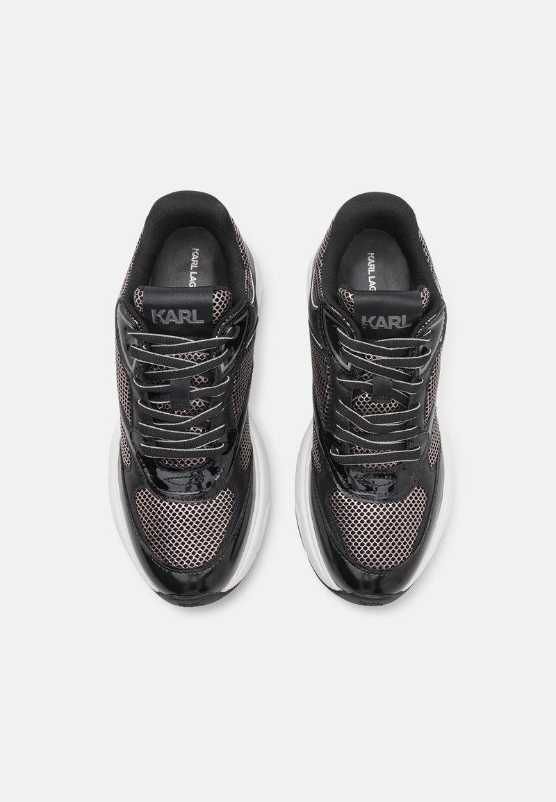 Zwarte en zilveren sport sneakers met een mesh bovenwerk, glanzende accenten en ronde veters. Voorzien van een verhoogde, gevoerde witte zool.