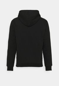 Sweat à capuche noir à manches longues avec poignets et taille côtelés, vu de dos sur un fond uni clair.