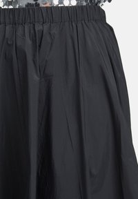 Schwarze knielange Rock aus leichtem, zerknittertem Stoff, mit einem elastischen Bund für Komfort und einer glatten Textur.